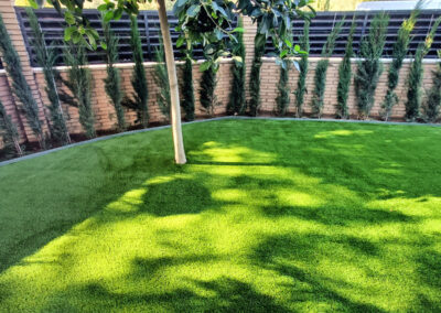 Enjardinament unifamiliar amb gespa artificial i plantació de seto de xiprer